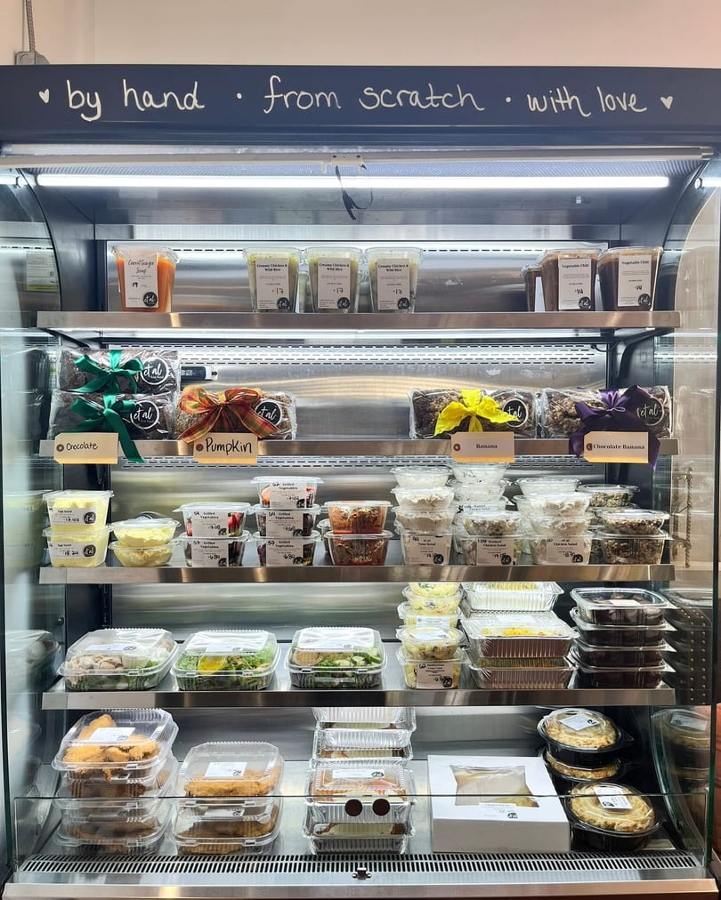 A refrigerated display case filled with various pre-packaged meals, salads, and desserts.